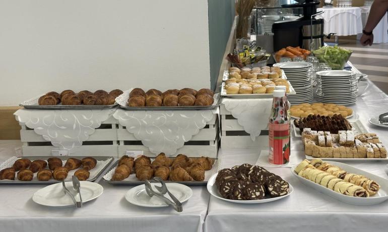 Buffet mit Gebäck, Croissants und bereitgestellten Tellern.