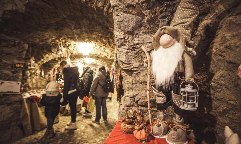 Weihnachtsmarkt in einer Höhle mit Dekorationen und Puppen.