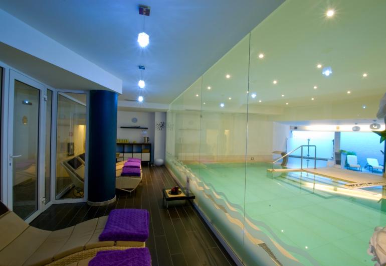 Indoor pool with loungers and a relaxing atmosphere.